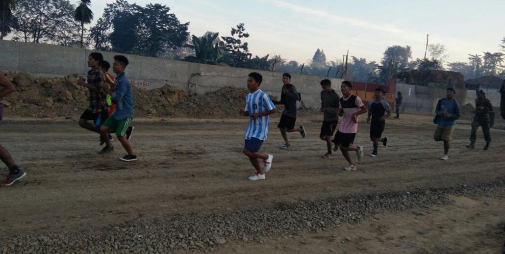 Youths running during a pre-recruitment training session.