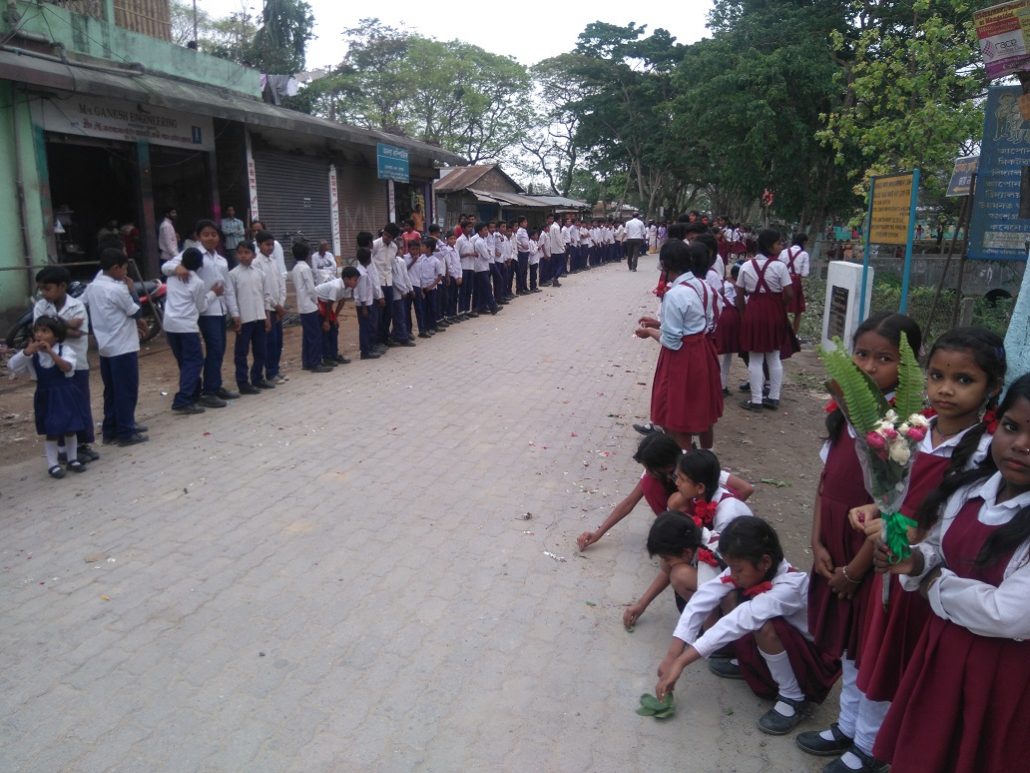 Children being exhausted after being stood for long seen sitting down on the street